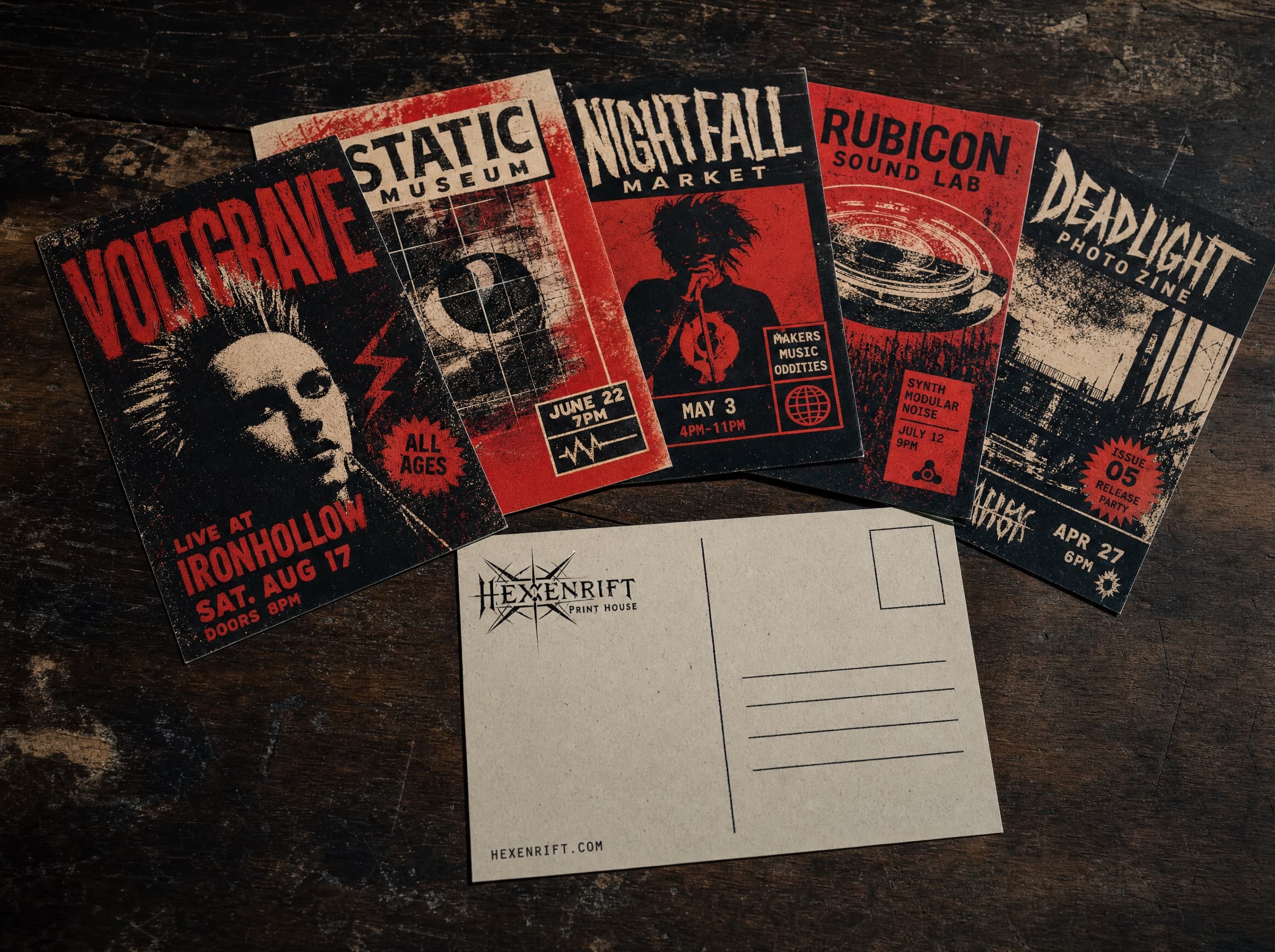 Screen-printed event postcards and flyers fanned across a dark wooden table.